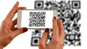 Example of how a QR code is used, showing a person scanning one with their phone to help people better understand Notify Me Tag.